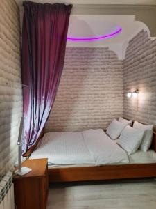 ein Schlafzimmer mit einem Bett mit einem lila Vorhang in der Unterkunft Двокімнатна студія з 3 ліжками Мережа AlexApartments Документи для відряджень Безконтатне заселення 24-7 in Shcherbani