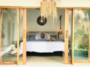a bedroom with a canopy bed with a teddy bear on it at AMAN Villas & SPA in Gili Islands