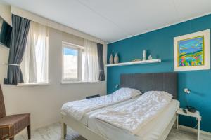 a bedroom with a bed with a blue wall at Appartementencomplex Juliana 148 in De Koog