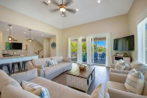a living room with white couches and a kitchen at Island Sol in Bradenton Beach