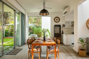 a kitchen and dining room with a wooden table and chairs at La Olalian by The Blue Kite - 2 & 3 BHK Designer Villas Near Anjuna Beach with Private Pool & Sun Deck & Garden in Anjuna +223 photos