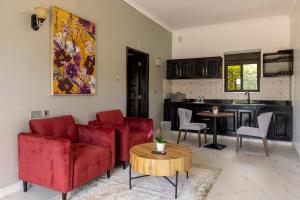 a living room with red couches and a kitchen at Master Peace Resort in Kyema