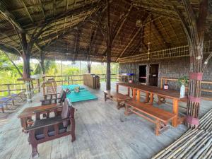 a pavilion with wooden benches and a table and a table at Tiger home stay Phayam in Ko Phayam