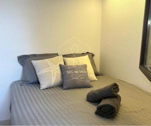 a bed with some pillows and a blanket on it at LONDON CANNES, vue mer in Cannes