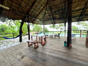 a pavilion with tables and benches and a hammock at Tiger home stay Phayam in Ko Phayam +13 photos