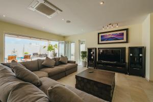 a living room with a large couch and a tv at LUX 2BR Pool 5mins Beach Villa Ocean by Bocobay in Palm-Eagle Beach