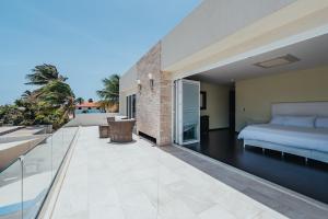 a bedroom on the balcony of a house at LUX 2BR Pool 5mins Beach Villa Ocean by Bocobay in Palm-Eagle Beach +30 photos