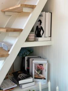 a shelf under a staircase with books and photographs at Tiny Escape Charlotte in Pak Chong