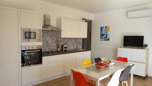 a kitchen with white cabinets and a table with chairs at Villa Saint George in Scopello