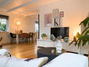 un salon avec un canapé et une télévision dans l'établissement Charming Decorated House in Nature, à Zuidwolde