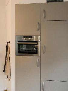 un four en acier inoxydable dans une cuisine à côté d'un réfrigérateur dans l'établissement Charming Decorated House in Nature, à Zuidwolde