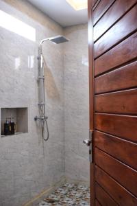 a bathroom with a shower with a wooden door at Intan sidemen villa in Sidemen +57 photos