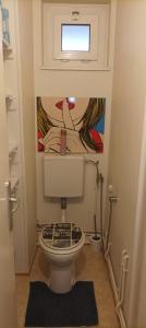 a bathroom with a toilet with a painting on the wall at La Meinau in Strasbourg +31 photos