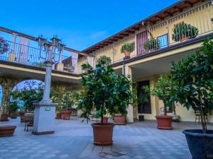 a courtyard with potted trees and a street light at Residence Garda Valtenesi in Puegnano del Garda
