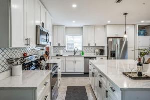 a kitchen with white cabinets and white counter tops at Beautiful Comfy Home With Private Hot Tub Close To Beach home in Fort Lauderdale
