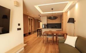 a living room and kitchen with a table and chairs at Monterra Jahorina in Jahorina