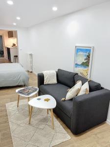 - un salon avec un canapé noir et un lit dans l'établissement Studio La Marne Paris, à Saint-Maur-des-Fossés