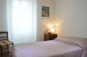 a bedroom with a bed and a chair and a window at Mais 4 pièces 5 couchages BANYULS SUR MER BN000-05B in Banyuls-sur-Mer