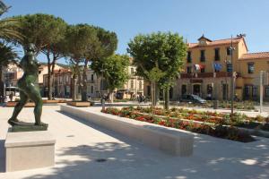 a statue in a park with flowers and buildings at Mais 4 pièces 5 couchages BANYULS SUR MER BN000-05B in Banyuls-sur-Mer