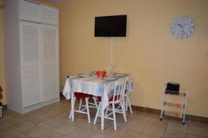 a dining room table with chairs and a clock on the wall at Appart Studio cabine 4 couchages BANYULS SUR MER BN010-001 in Banyuls-sur-Mer