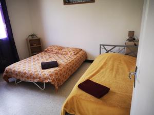 two beds in a small room with two towels at La maisonnette in Cléry-Saint-André