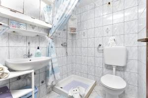 a white bathroom with a toilet and a sink at Apartments and rooms Murage 2369 in Barbariga +50 photos