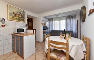 a small kitchen with a table and a microwave at Apartments and rooms Murage 2369 in Barbariga