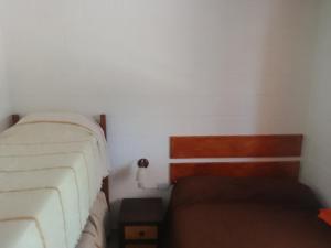 Un dormitorio pequeño con una cama y un sofá. en Cabaña Calamuchita Rumipal, en Villa Rumipal