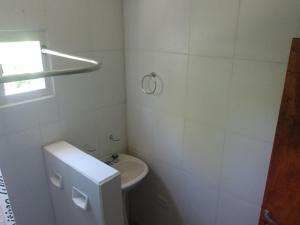 Un baño blanco con inodoro y lavabo. en Cabaña Calamuchita Rumipal, en Villa Rumipal