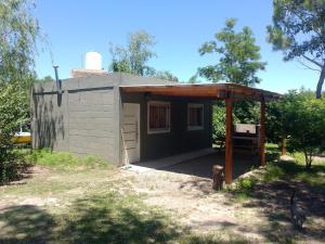 un pequeño edificio con un cobertizo con techo en Cabaña Calamuchita Rumipal, en Villa Rumipal