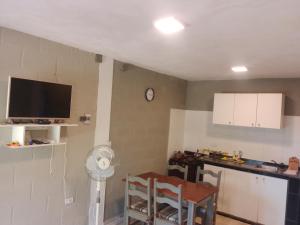 Una cocina con una mesa y un reloj en la pared. en Cabaña Calamuchita Rumipal, en Villa Rumipal 3 fotos más