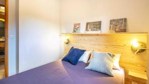 a bedroom with a bed with blue and white pillows at La Turra 312 - 3P4 in Modane