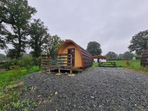 una piccola capanna di legno con una panchina in un campo di Cabane forestière près base nautique avec terrasse et parking - FR-1-591-647 a Pouligny-Notre-Dame