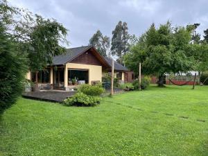 ein Haus mit einem grünen Hof mit einem Haus in der Unterkunft Casa verano piscina Villarrica in Villarrica