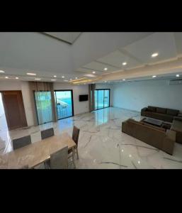 a large room with a couch and tables in it at Villa Green in Hammamet +21 photos