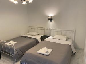 ein Zimmer mit zwei Betten mit Handtüchern darauf in der Unterkunft Angel's Apartment Volos in Volos
