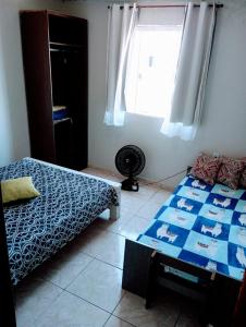 um quarto com duas camas e uma janela em Nosso Sonho em Rio das Ostras