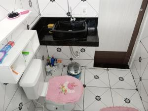 um pequeno banheiro com um vaso sanitário e uma pia em Nosso Sonho em Rio das Ostras