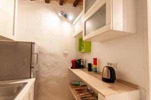 a small kitchen with white cabinets and a refrigerator at UC - Guest House Gerardo in Perugia