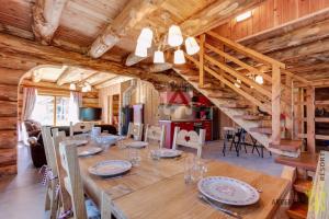 a dining room with a wooden table and a staircase at Chalet de Fougerousse in Chambon-sur-Lac
