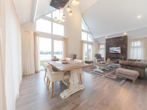 a living room with a table and a couch at Ruim en licht, comfortabel en stijlvol ingericht huis met uitzicht op het meer 16 in Wemeldinge