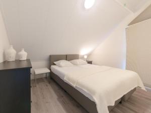 a white bedroom with a bed and a desk at Ruim en licht, comfortabel en stijlvol ingericht huis met uitzicht op het meer 16 in Wemeldinge