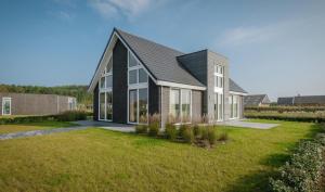 a house with a black roof at Ruim en licht, comfortabel en stijlvol ingericht huis met uitzicht op het meer 16 in Wemeldinge