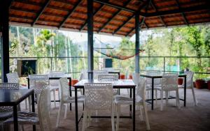 a group of tables and chairs in a restaurant at Beehive staycations in Ambalavayal