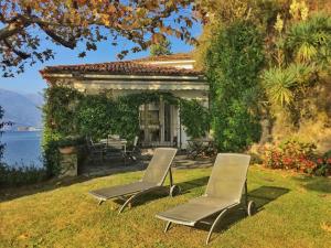 two chairs sitting in the grass in front of a house at On Lake Villa Cicci e Sandro in Bellano