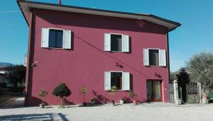 Una casa roja con persianas blancas. en B&B River, en Ascoli Piceno