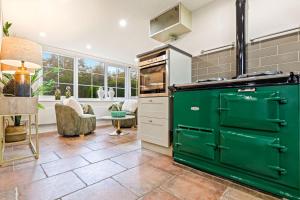 a kitchen with green cabinets and a living room at Great Easton Lodge in Great Easton +25 photos