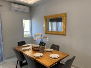 ein Esszimmer mit einem Holztisch und Stühlen in der Unterkunft Angel's Apartment Volos in Volos + 18 Fotos