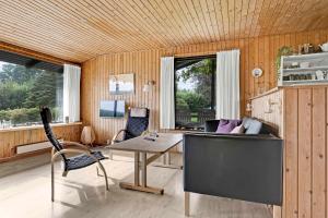 a living room with a table and a couch at Holiday Home 100 Meters From A Lovely Beach in Tranekær