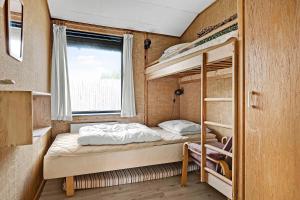two bunk beds in a small room with a window at Holiday Home 100 Meters From A Lovely Beach in Tranekær